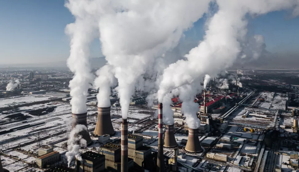 Industrial smoke stacks emit steam in winter 